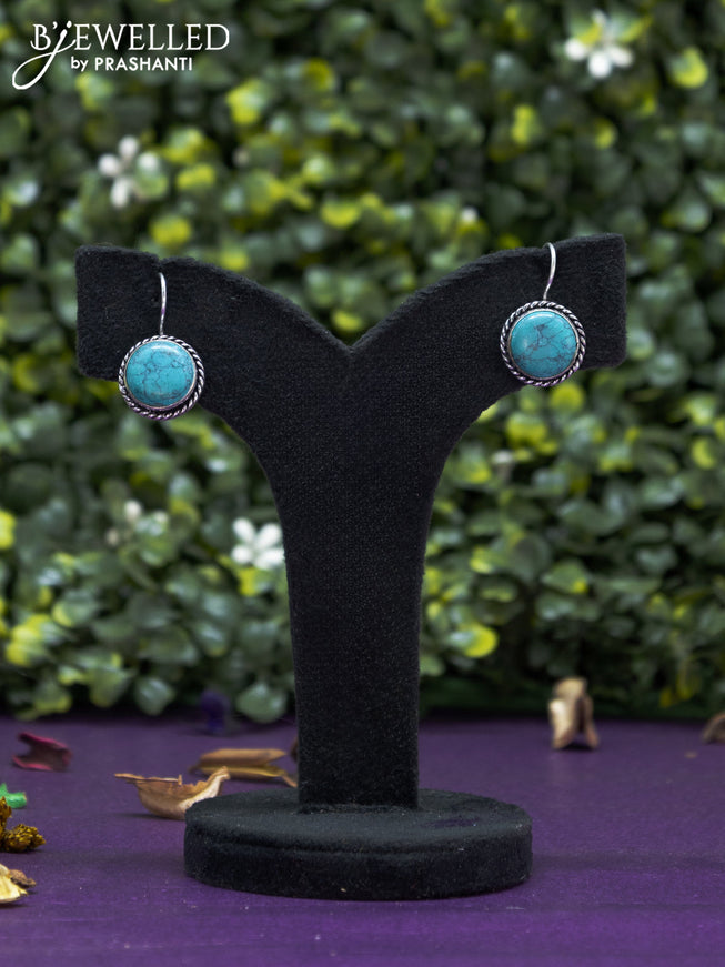 Oxidised hanging type earring with light blue stones