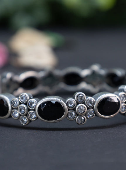 Oxidised floral design screw type bangle with black and cz stones