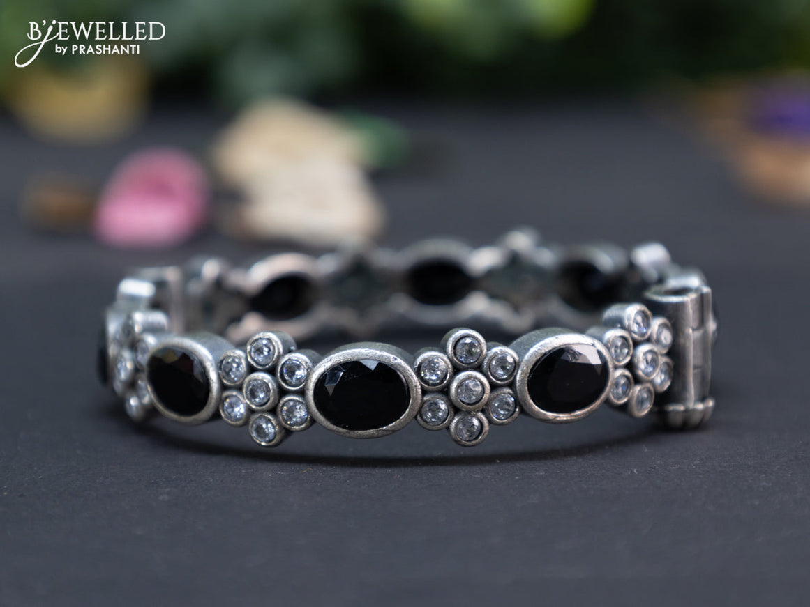 Oxidised floral design screw type bangle with black and cz stones