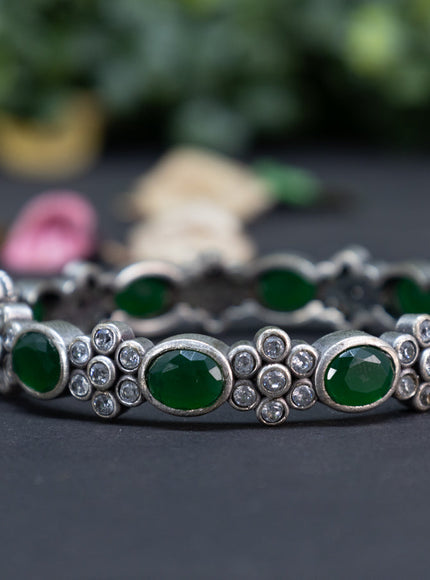 Oxidised floral design screw type bangle with emerald and cz stones