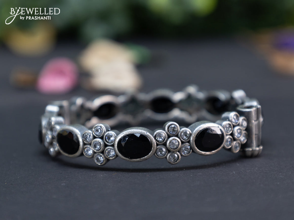 Oxidised floral design screw type bangle with black and cz stones