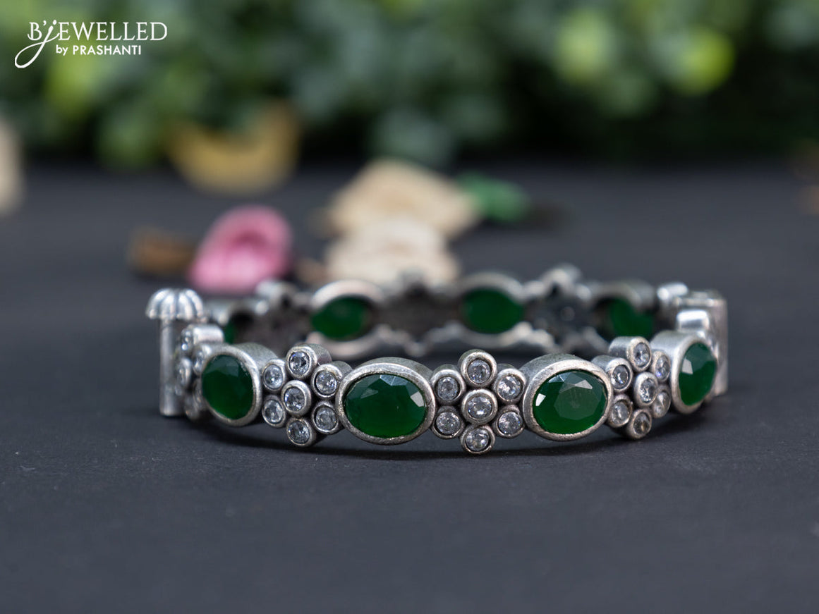 Oxidised floral design screw type bangle with emerald and cz stones