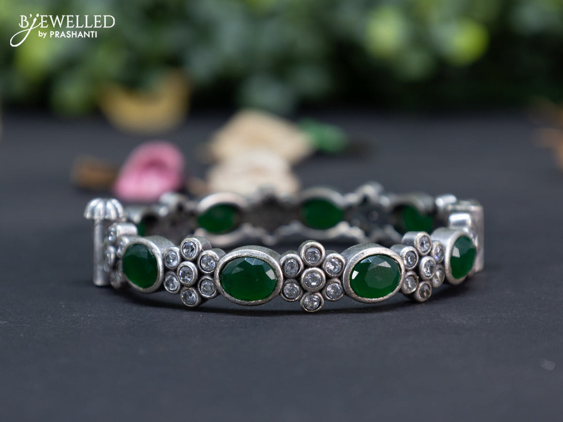 Oxidised floral design screw type bangle with emerald and cz stones