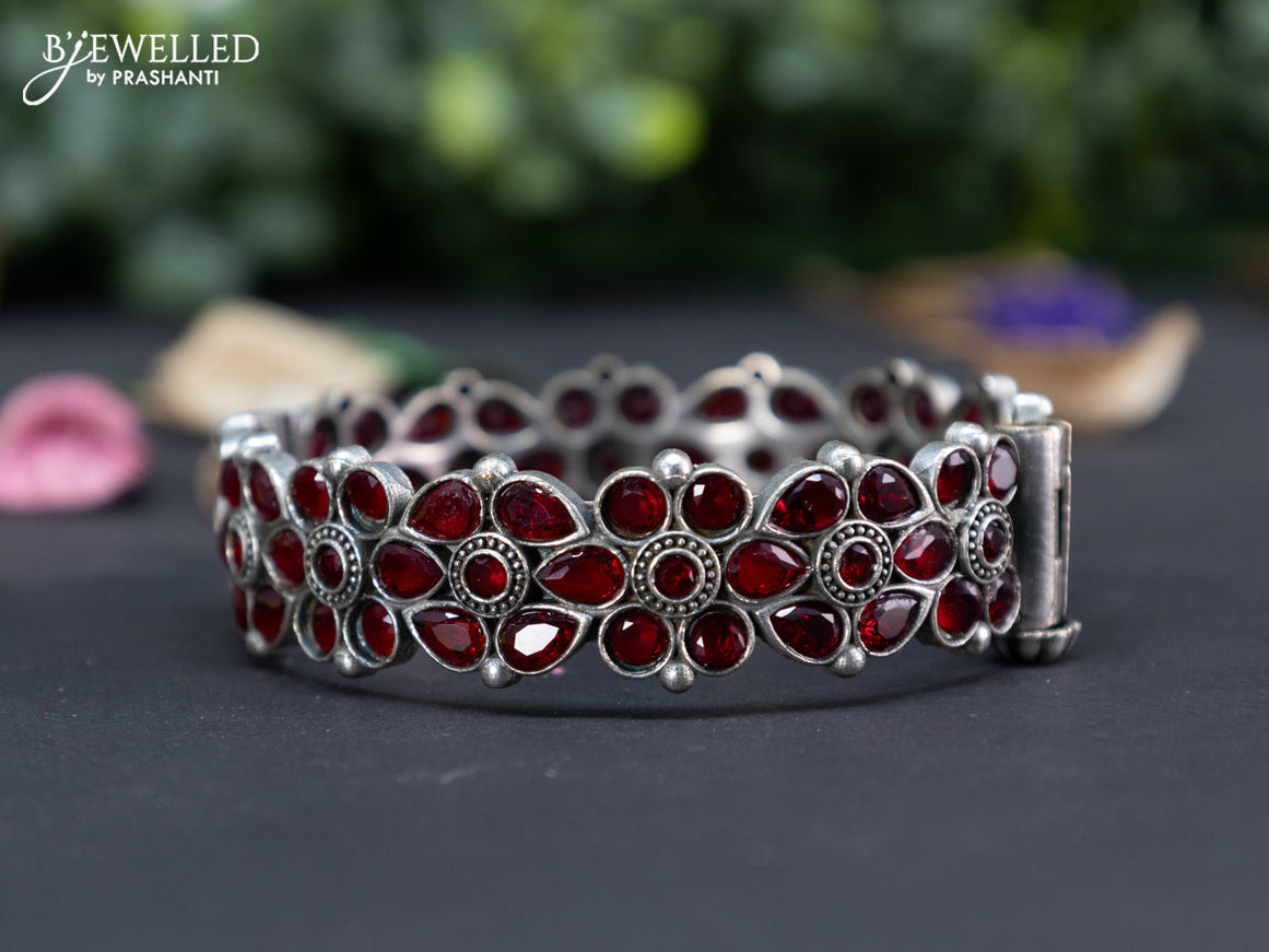 Oxidised floral design screw type bangle with maroon stones