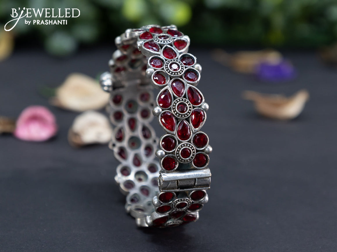 Oxidised floral design screw type bangle with maroon stones