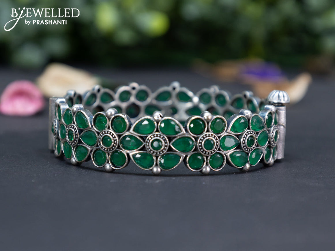 Oxidised floral design screw type bangle with emerald stones