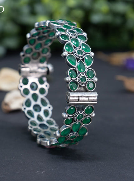 Oxidised floral design screw type bangle with emerald stones