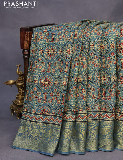 Dola silk saree blue shade with allover ajrakh prints and zari woven border