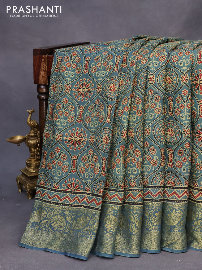 Dola silk saree blue shade with allover ajrakh prints and zari woven border