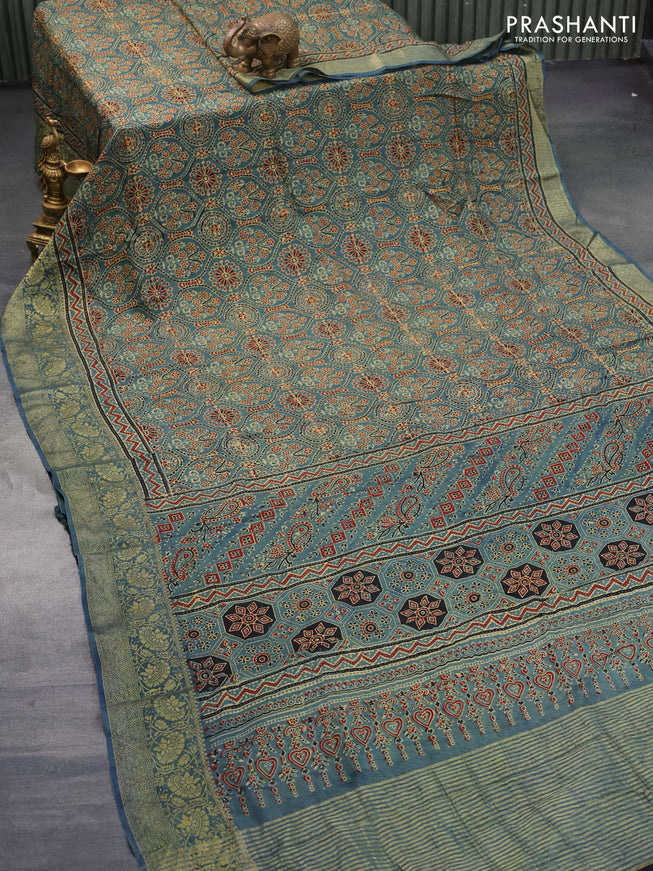 Dola silk saree blue shade with allover ajrakh prints and zari woven border