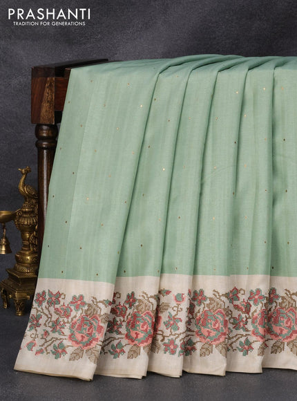 Tussar silk saree pastel green and cream with allover zari buttas and floral design cross stitched embroidery border