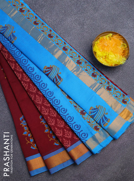 Silk cotton block printed saree maroon and cs blue with allover prints and zari woven border