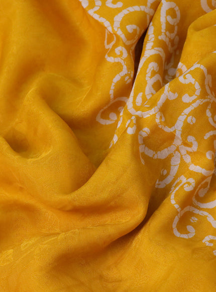 Semi crepe saree mango yellow with allover self emboss and batik printed border