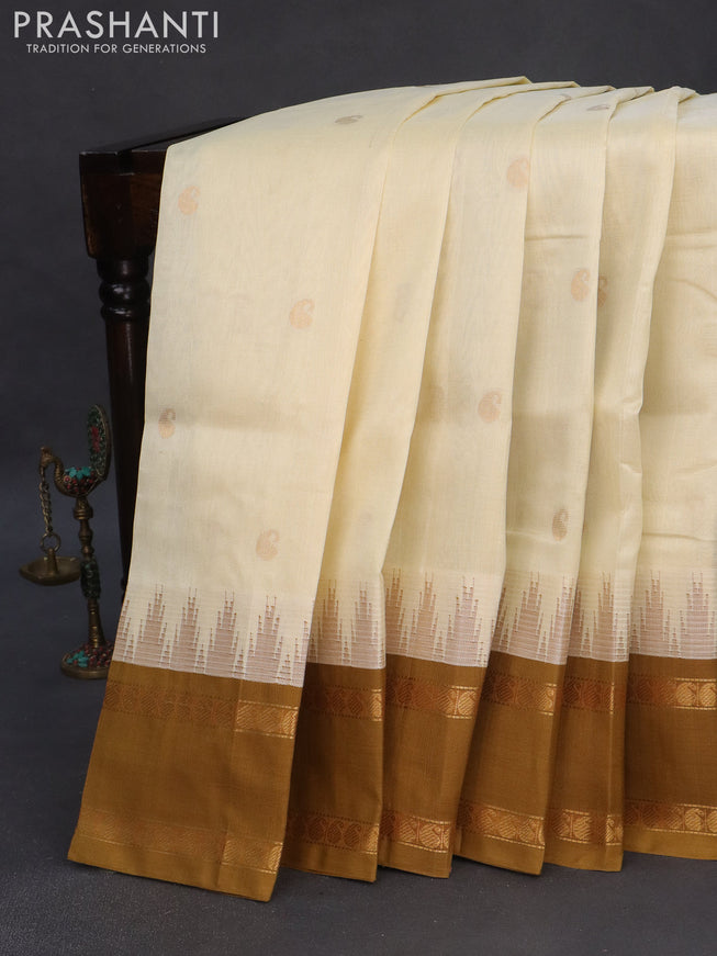 Silk cotton saree cream and dark mustard with zari woven paisley buttas and temple design rettapet zari woven korvai border