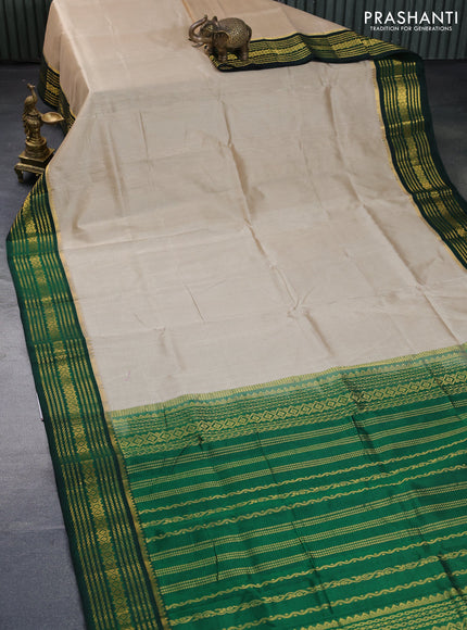 Silk cotton saree beige and green with plain body and zari woven korvai border