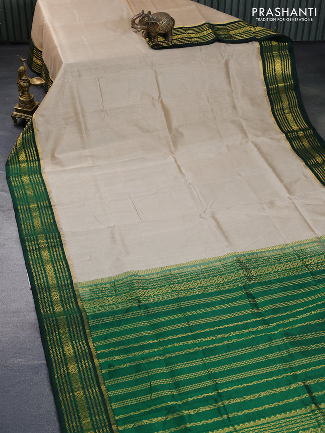 Silk cotton saree beige and green with plain body and zari woven korvai border