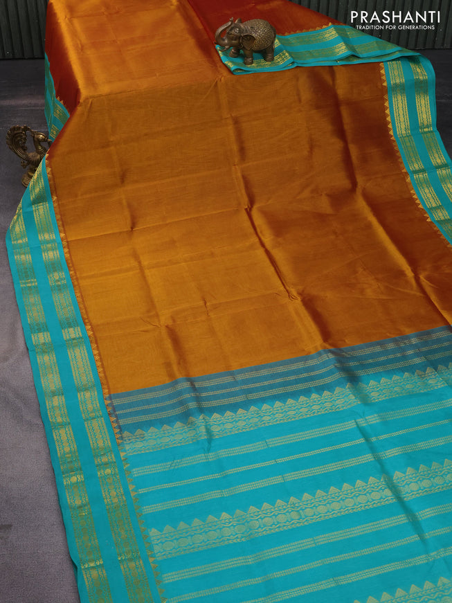 Silk cotton saree dual shade of dark mustard and teal blue with plain body and zari woven korvai border