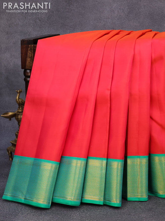 Pure kanjivaram silk saree dual shade of pinkish orange and teal green with plain body and rich zari woven border plain body