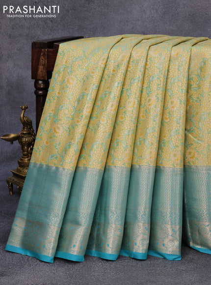 Tissue semi kanjivaram saree yellow shade and teal blue with allover floral brocade weaves and long zari woven border