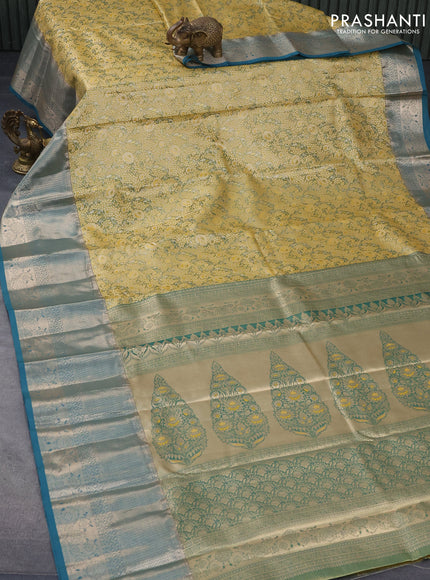 Tissue semi kanjivaram saree mustard shade and peacock green with allover floral brocade weaves and long zari woven border