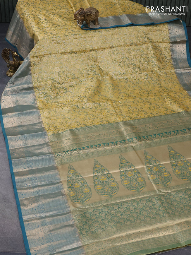 Tissue semi kanjivaram saree mustard shade and peacock green with allover floral brocade weaves and long zari woven border