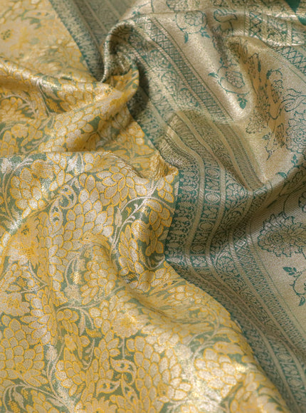 Tissue semi kanjivaram saree mustard shade and peacock green with allover floral brocade weaves and long zari woven border