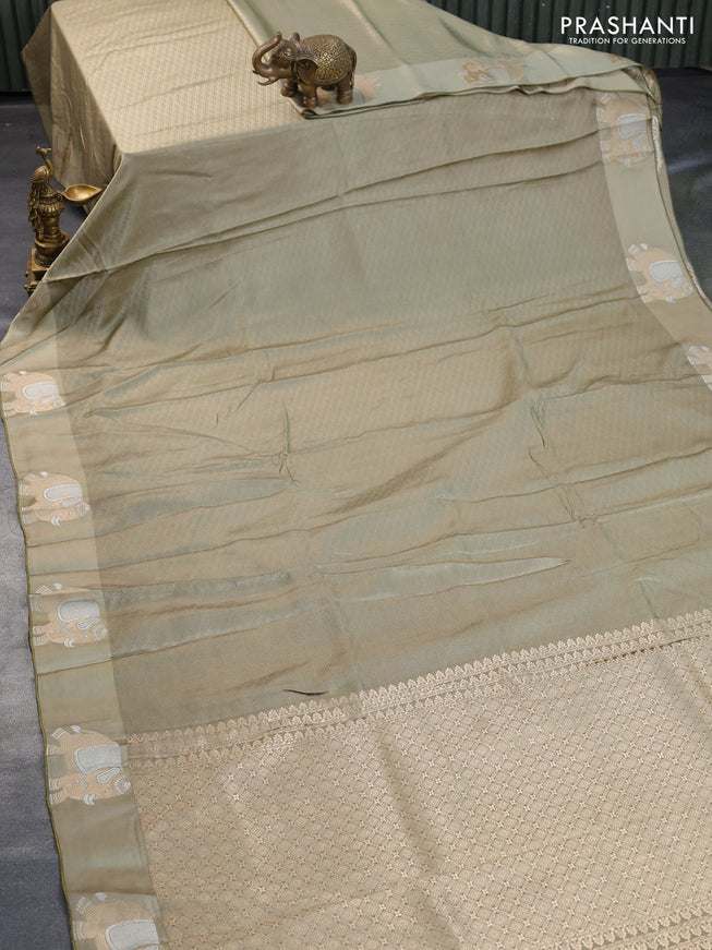 Mushru silk saree elaichi green with allover self emboss and elephant zari woven butta border