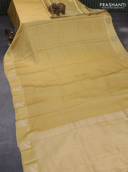 Mushru silk saree yellow shade with allover self emboss and zari woven butta border