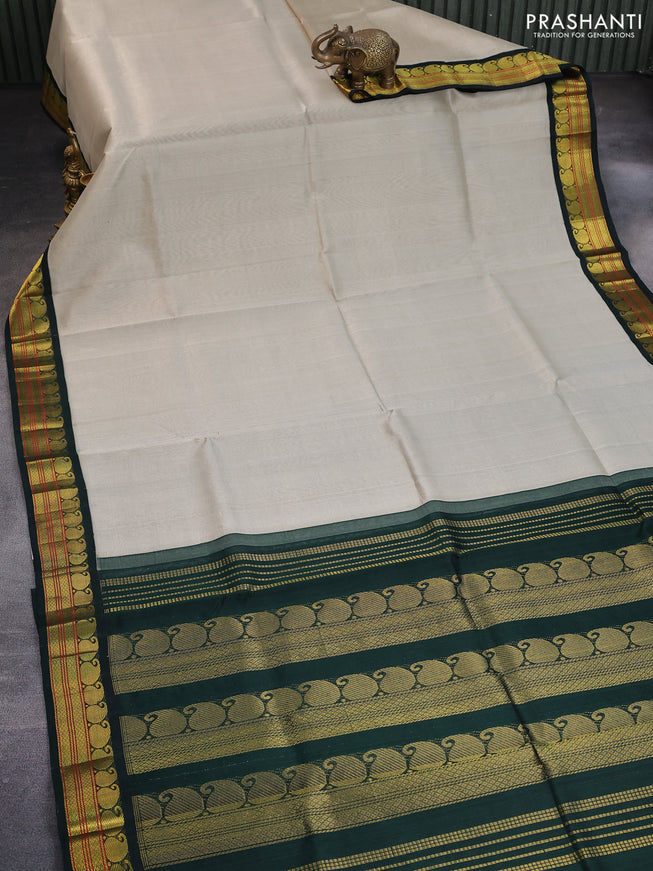 Silk cotton saree beige and bottle green with plain body and paisley zari woven korvai border