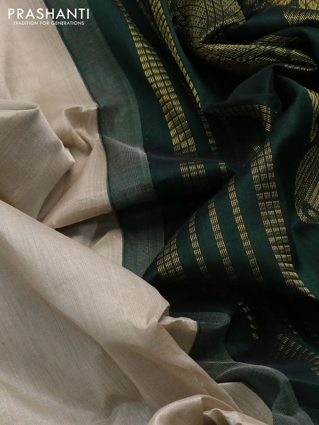 Silk cotton saree beige and bottle green with plain body and paisley zari woven korvai border