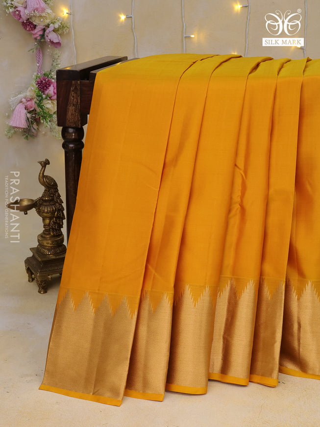 Pure kanchipuram silk saree mustard yellow with plain body and temple design zari woven border