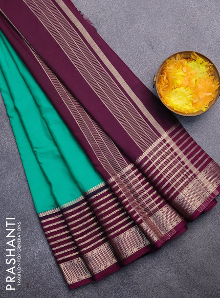 Semi crepe saree teal green and purple with plain body and long zari woven border