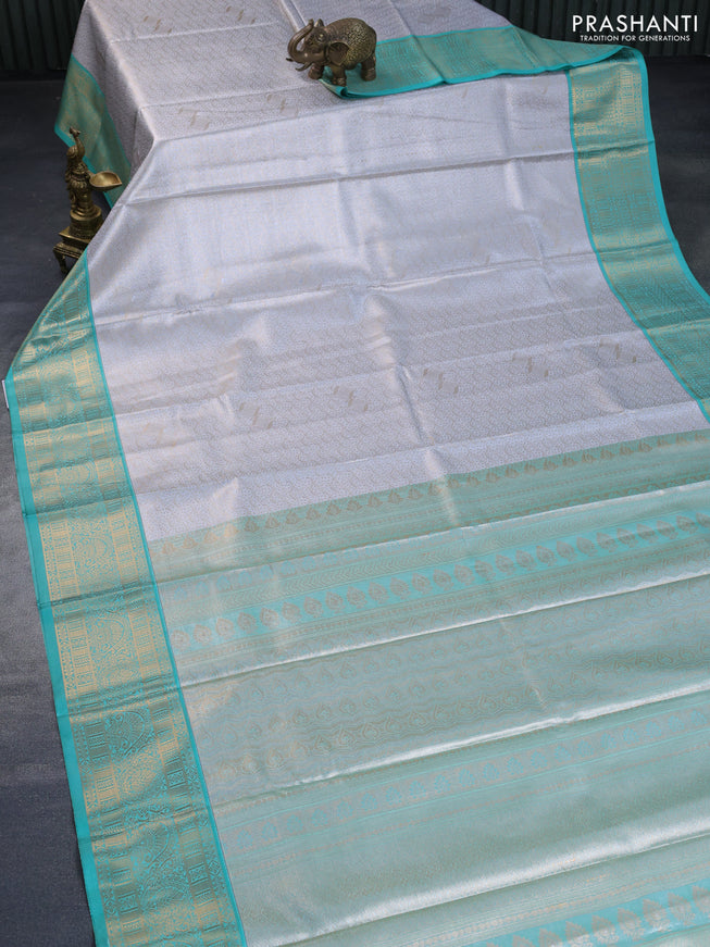 Tissue semi kanchipuram saree pastel grey and teal green shade with allover zari woven brocade weaves and rich zari woven korvai border