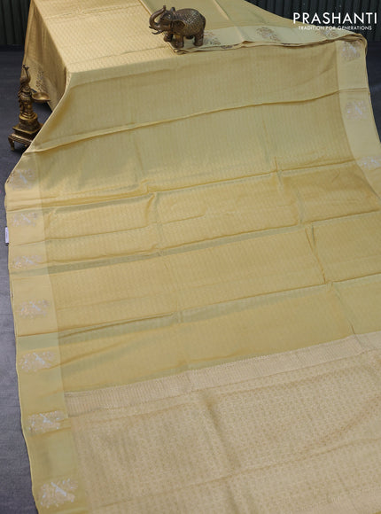 Mushru silk saree pale yellow with allover self emboss and zari woven butta border