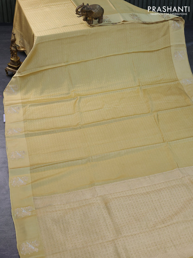 Mushru silk saree pale yellow with allover self emboss and zari woven butta border