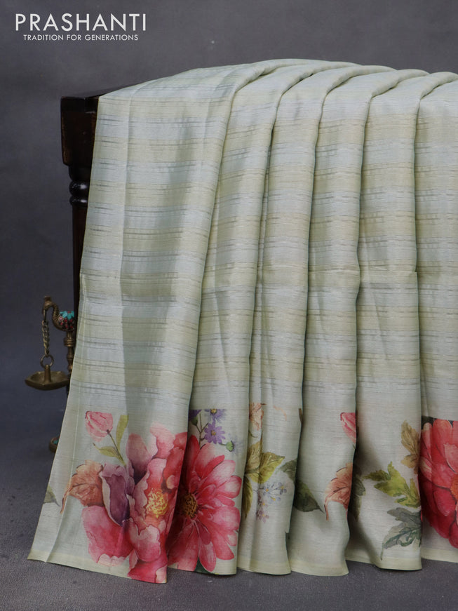 Semi tussar saree pastel green shade with allover silver zari strips & floral digital prints and floral digital printed border