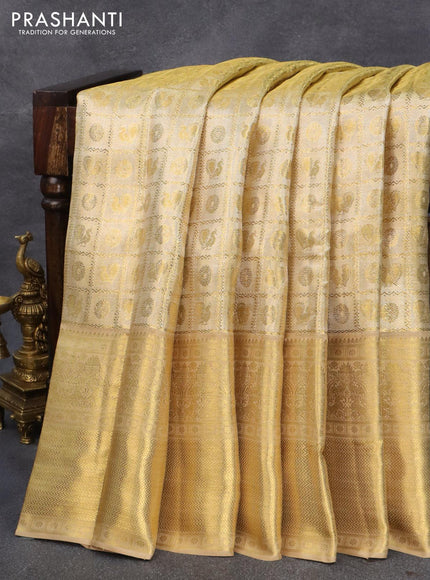 Pure kanjivaram tissue silk saree gold with allover zari woven brocade weaves and long zari woven border