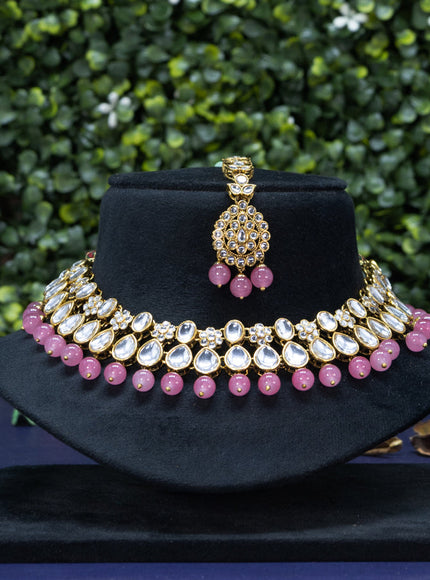 Kundan necklace with pink beads hanging and maang tikka