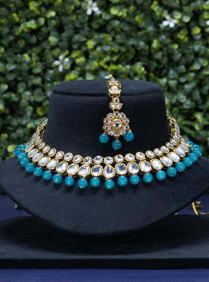 Kundan necklace with blue beads hanging and maang tikka