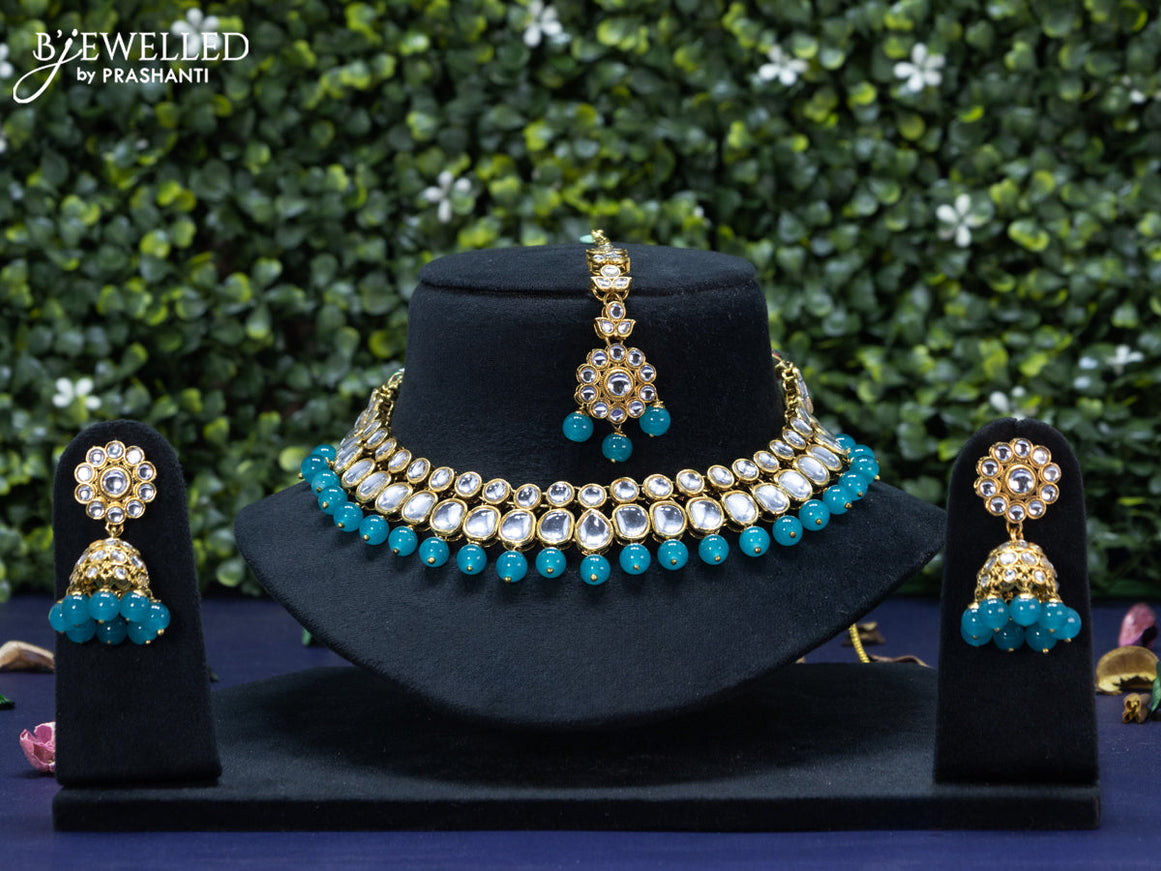 Kundan necklace with blue beads hanging and maang tikka