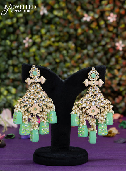 Fashion dangler cream earrings minakari work with kundan stones and teal green beads hangings