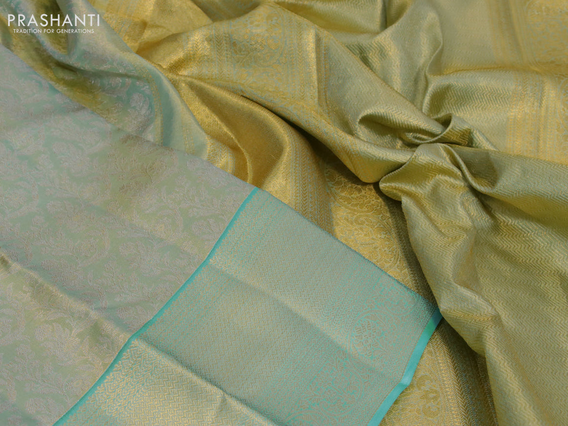 Kanchipuram tissue silk saree dual shade of bluish gold and teal blue with allover zari woven floral brocade weaves and zari woven border