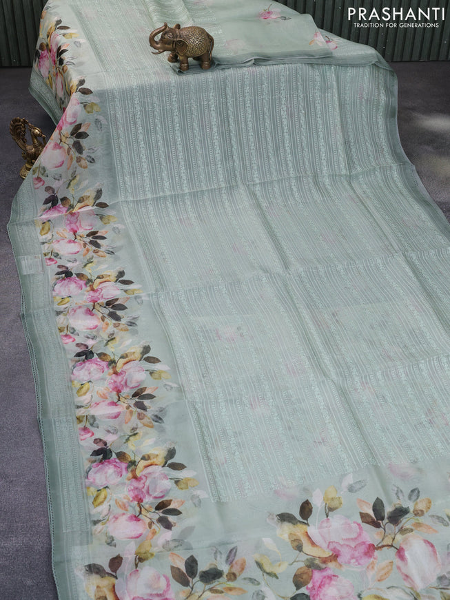 Pure organza partly silk saree pastel blue shade with embroidery work buttas and floral printed embroidery work border